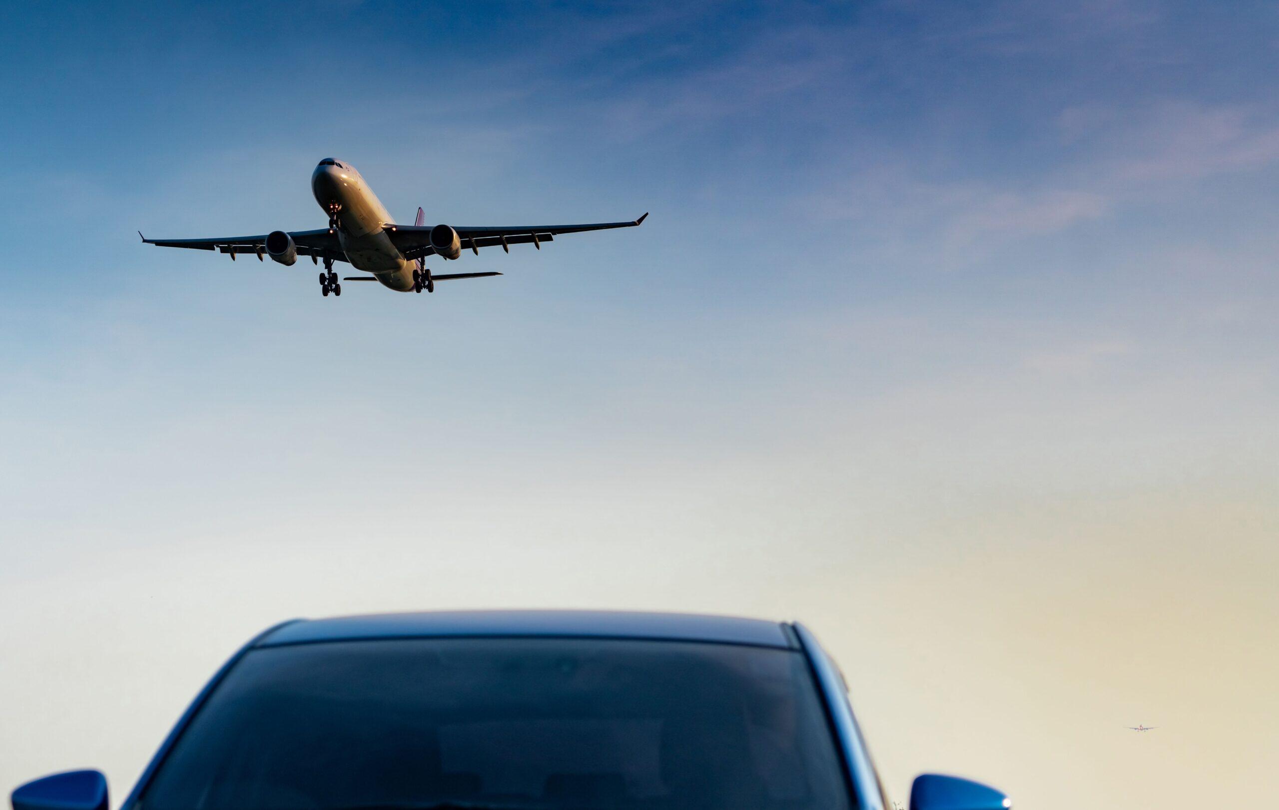 Ein Flugzeug im Landeanflug über einem Auto