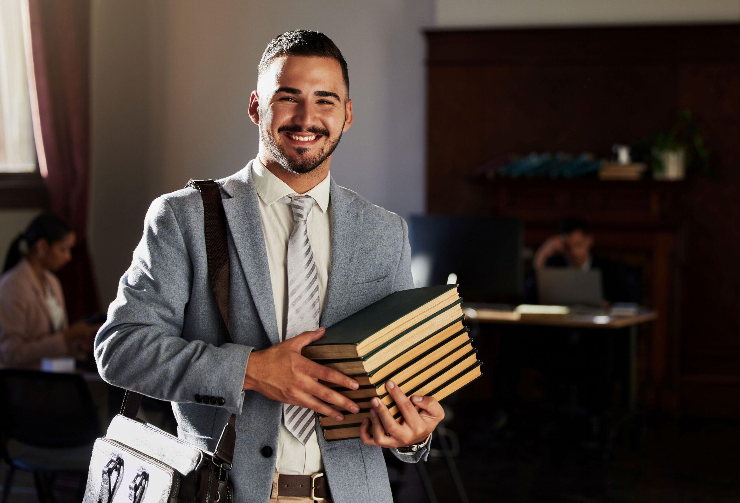 Ein Mann im Anzug mit vielen Büchern in der Hand