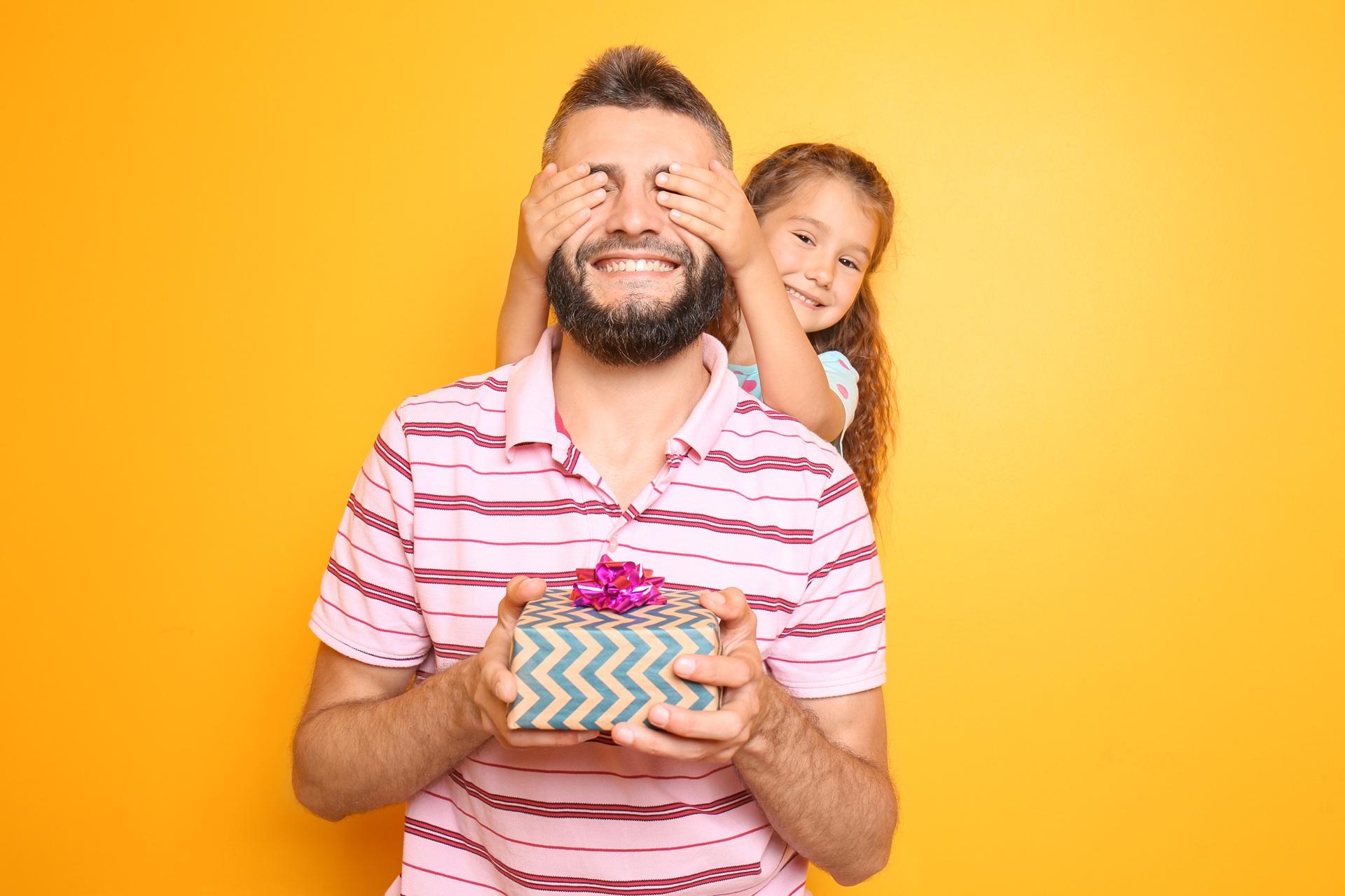Kind ueberrascht Vater mit Geschenk | Präsentkorb