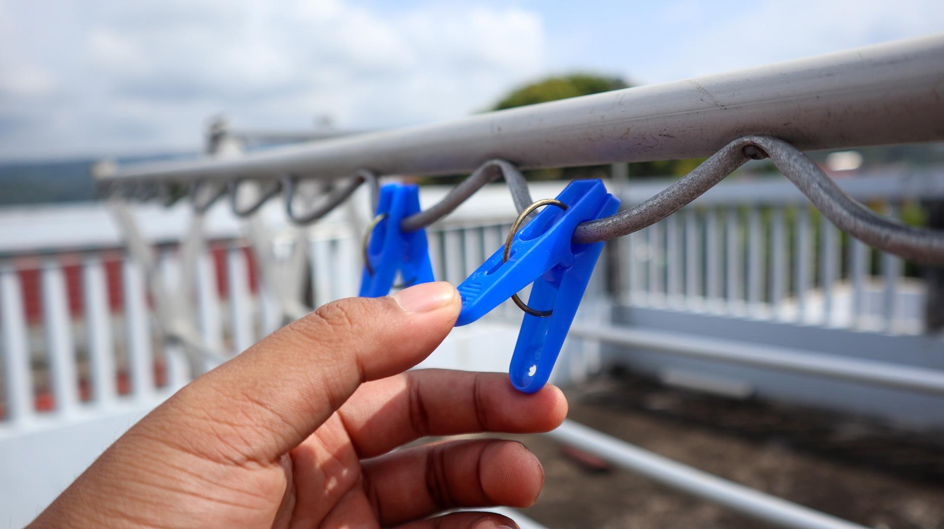 Blaue Wäscheklammern auf Draht im Freien | Solarschlauch Pool