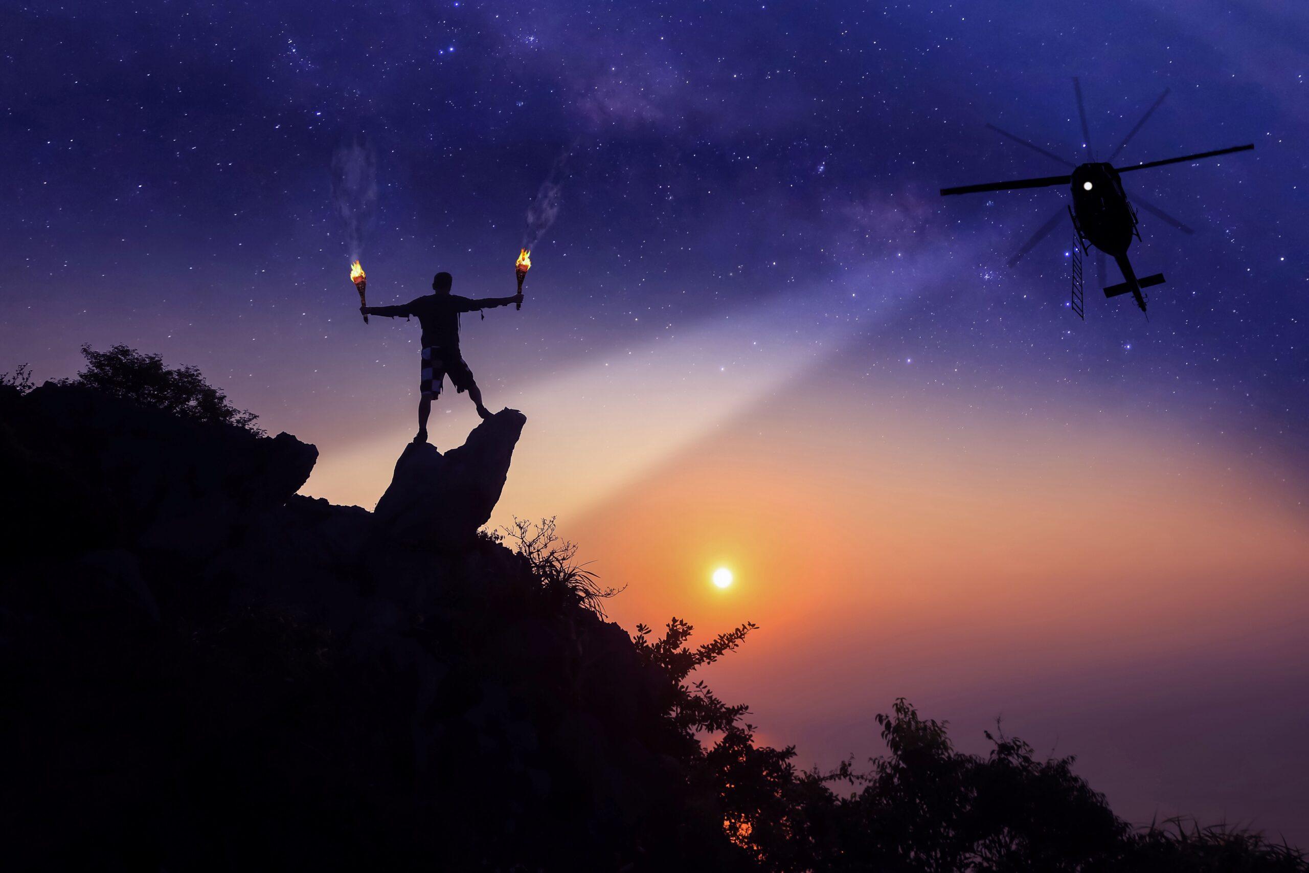 Person auf Felsen sendet mit Signalmunition deutliche Notsignale aus